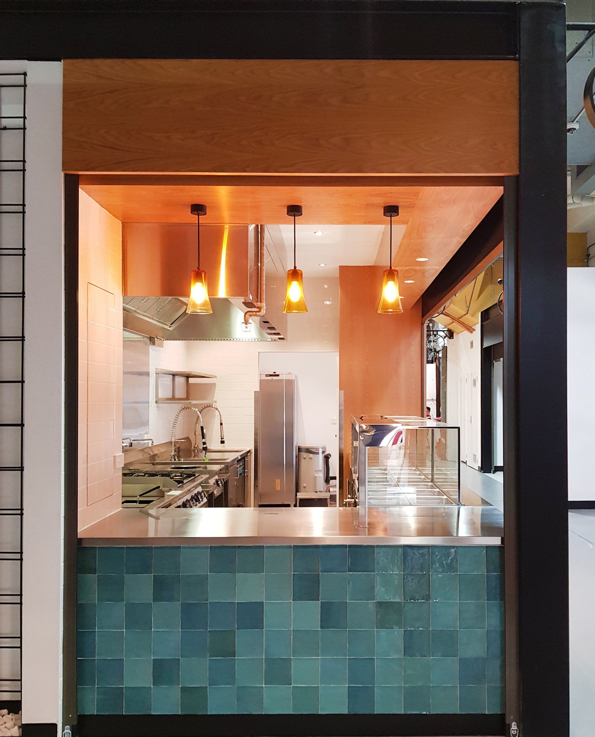A kitchen with a stainless steel counter and blue tiles