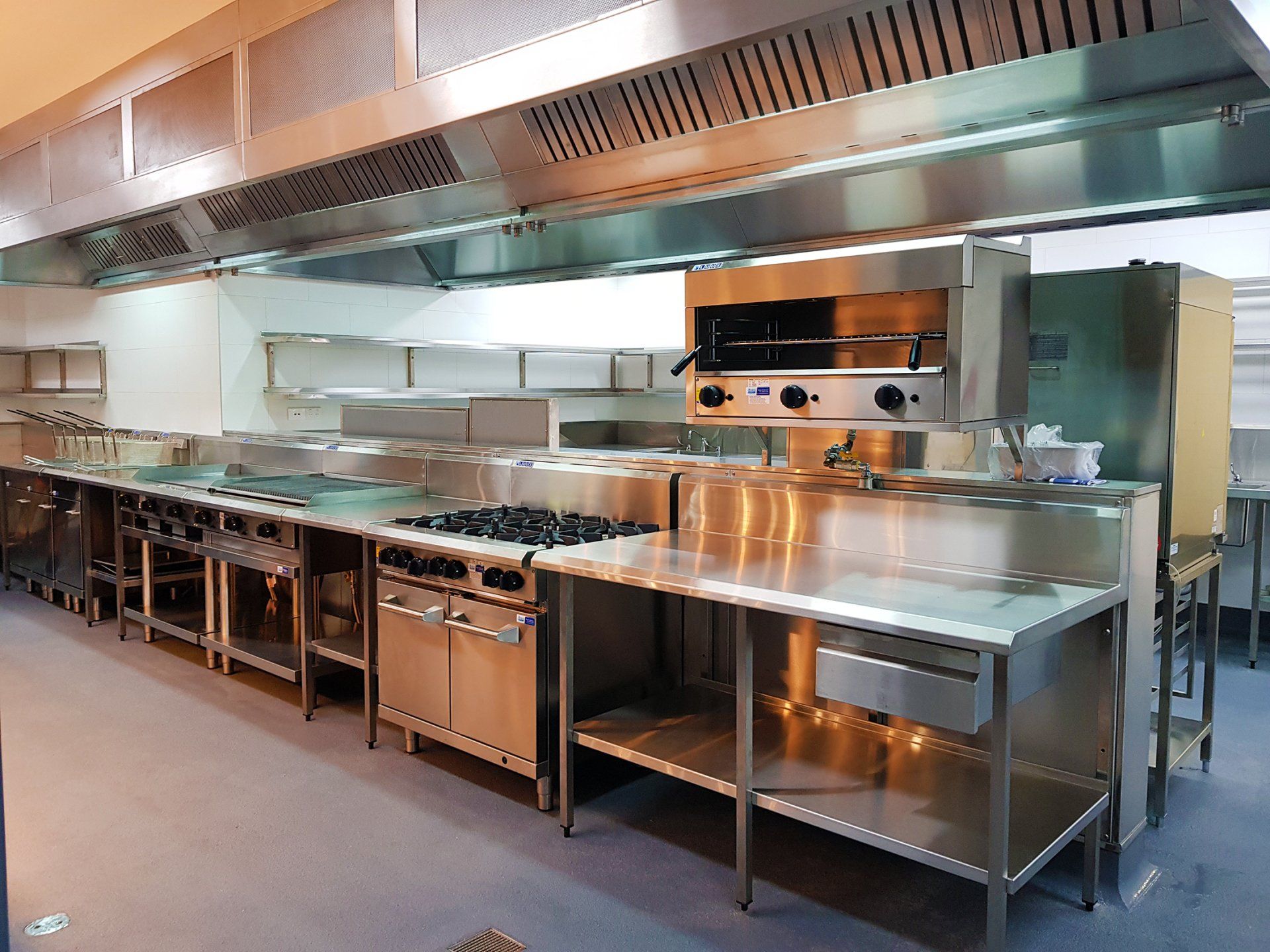 A large kitchen with a lot of stainless steel appliances