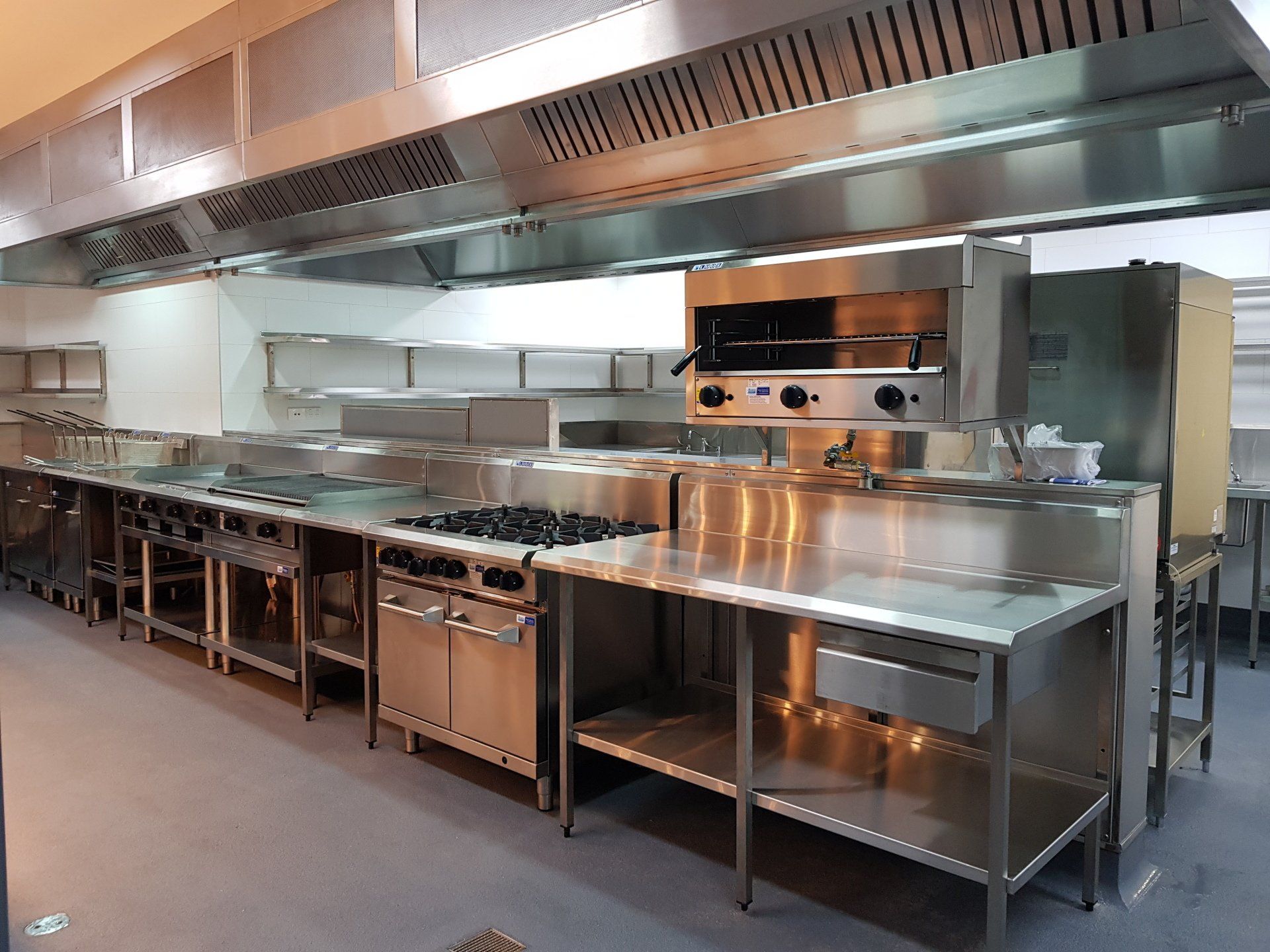A large kitchen with a lot of stainless steel appliances.