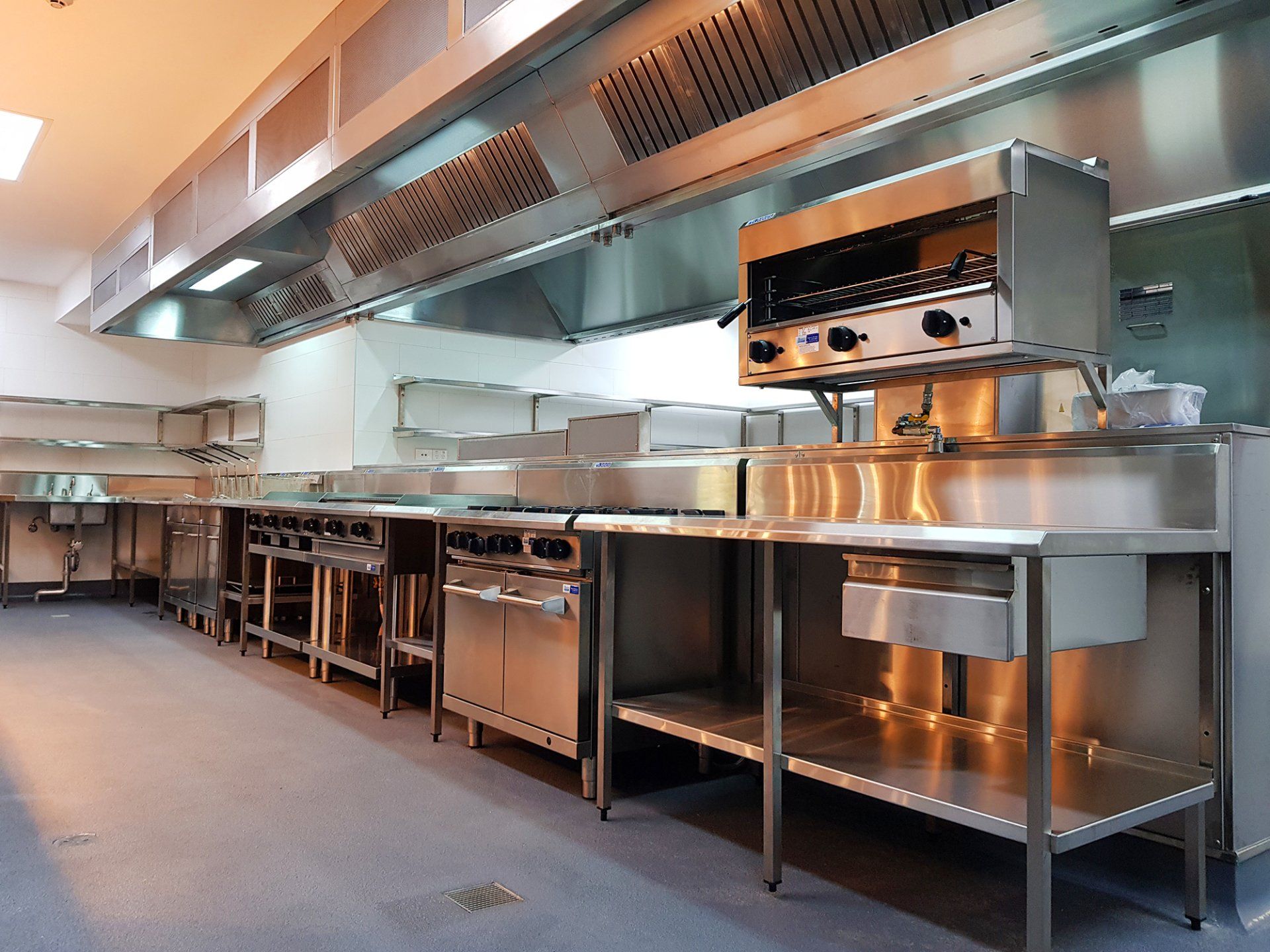 A large commercial kitchen with stainless steel appliances and counters.