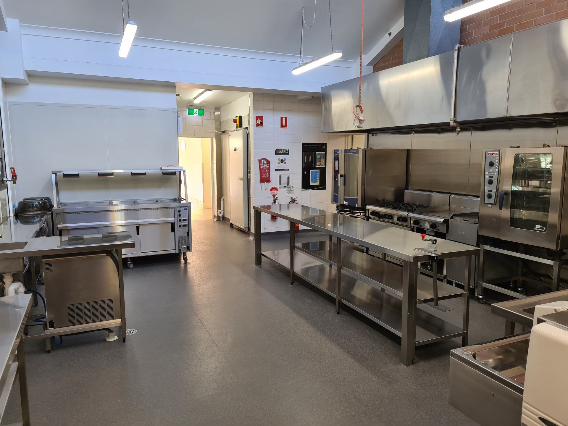 A large kitchen with a lot of stainless steel appliances.