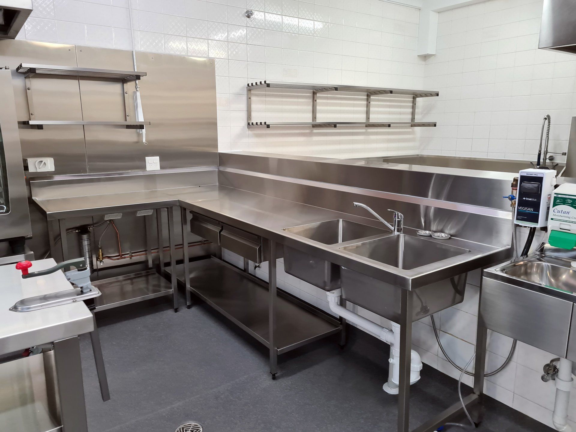 A kitchen with stainless steel counter tops and sinks