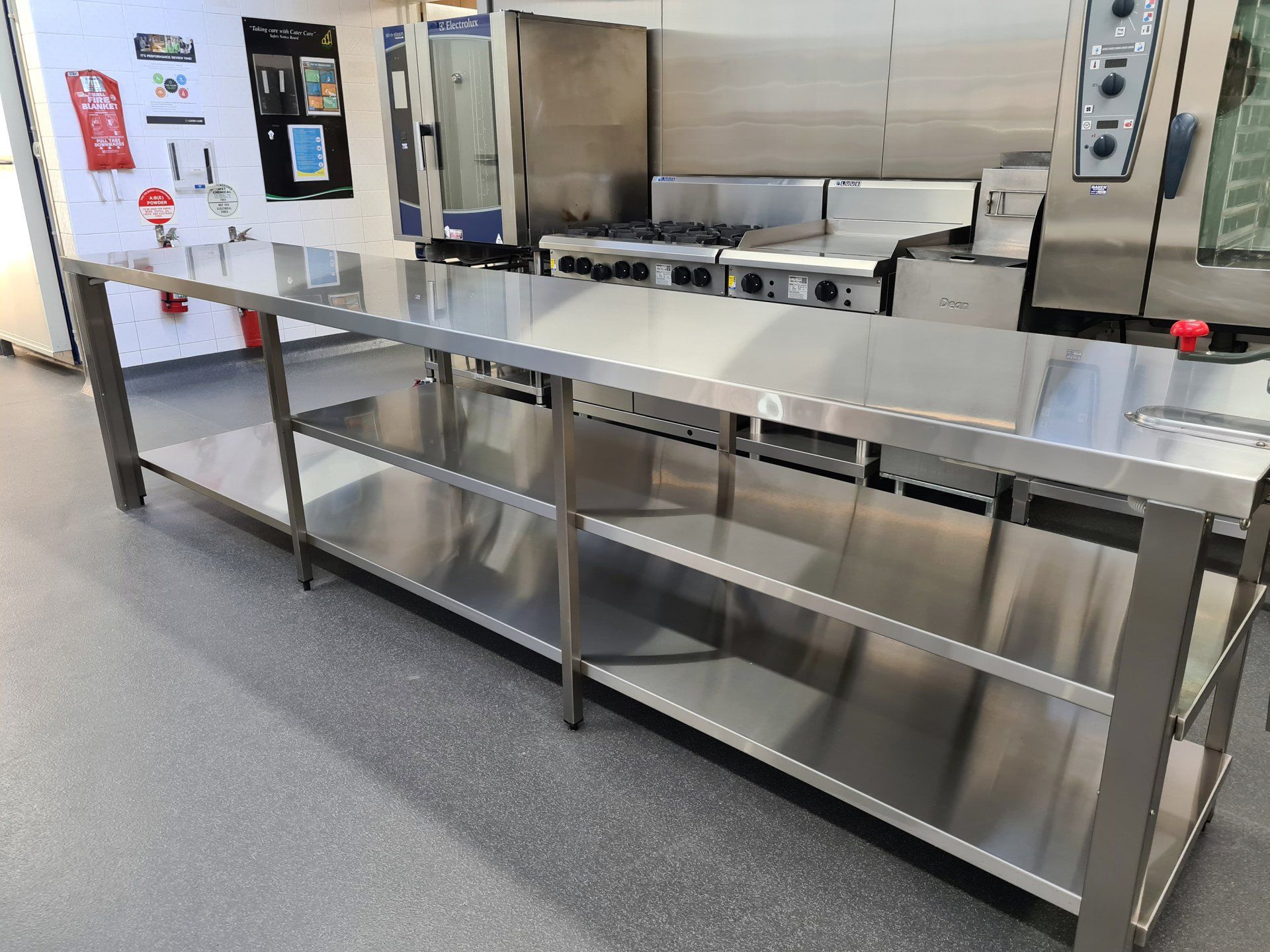 A stainless steel table with shelves in a kitchen.