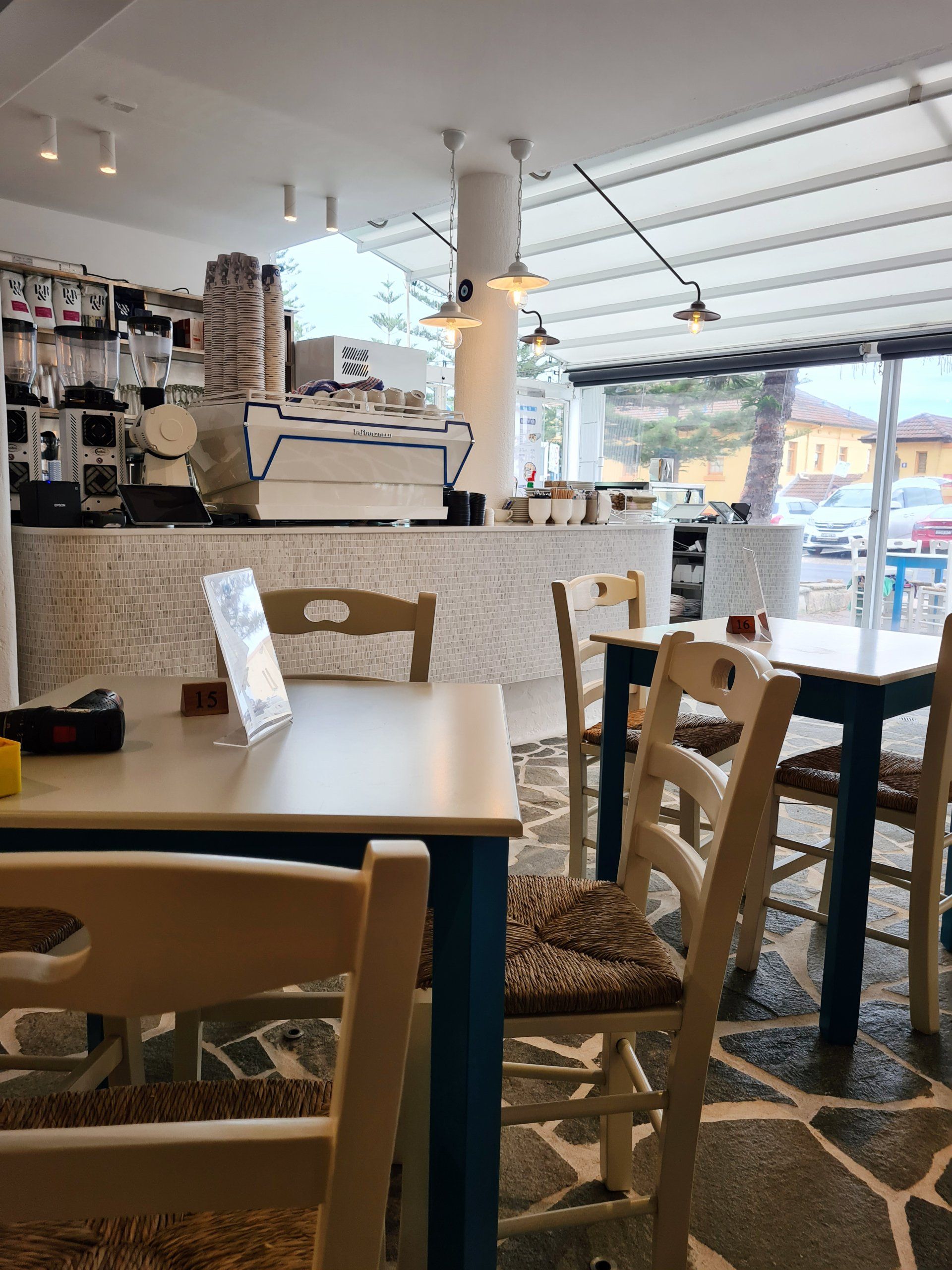A restaurant with tables and chairs and a counter