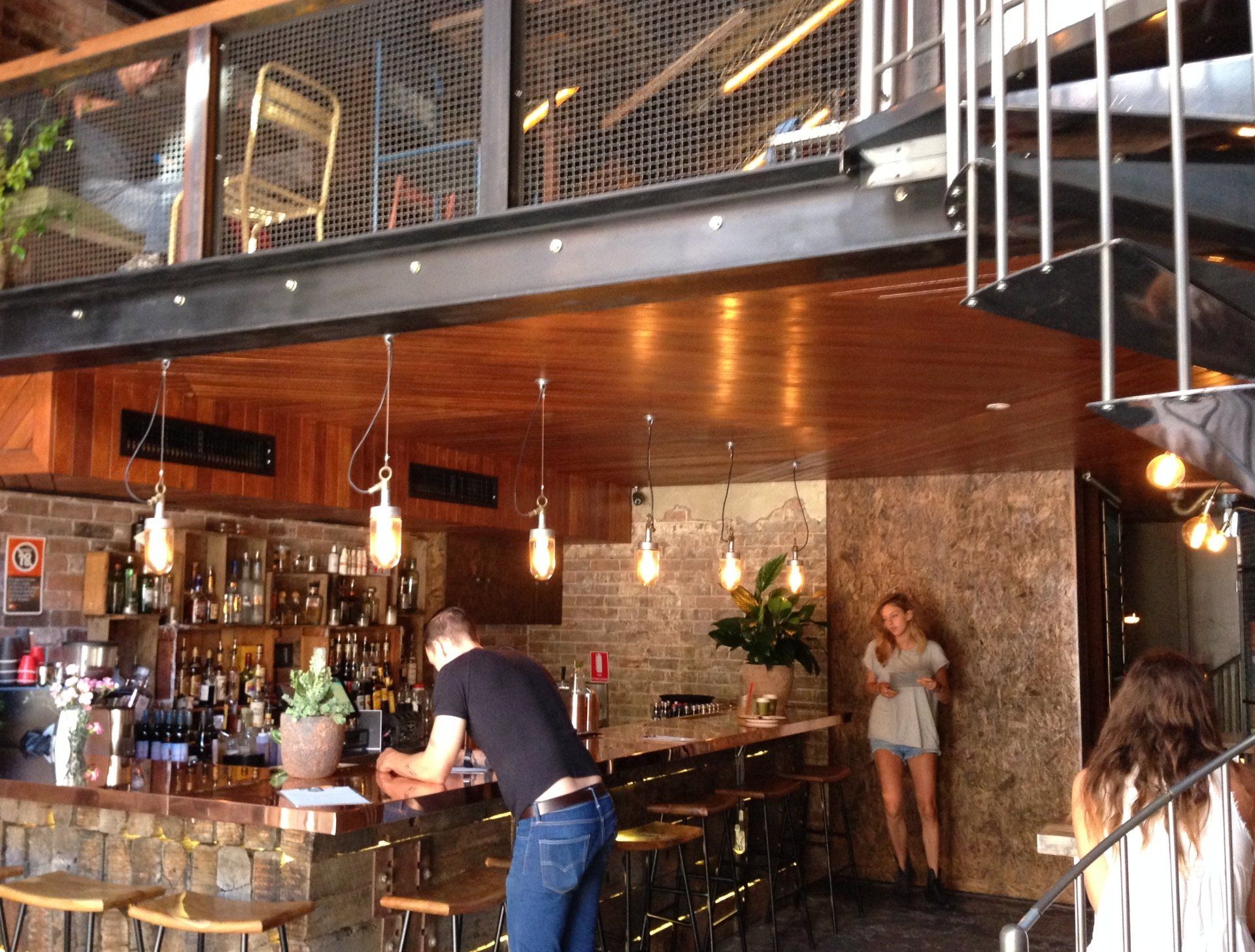 A man is standing at a bar in a restaurant
