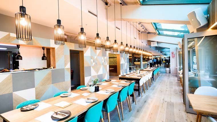 A long dining room with tables and chairs in a restaurant.