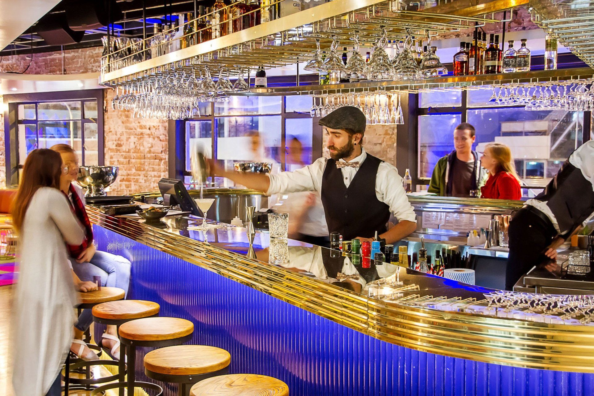 A group of people are sitting at a bar in a restaurant.