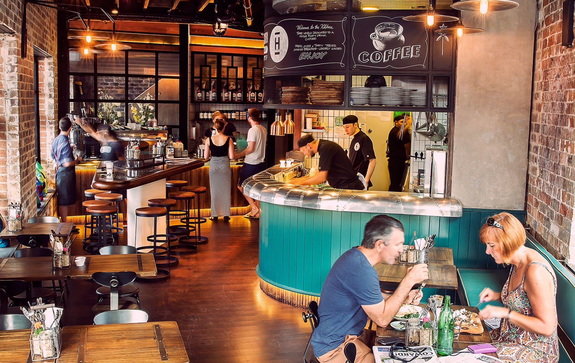A group of people are sitting at tables in a restaurant.