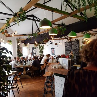 A group of people are sitting at tables in a restaurant.