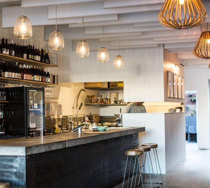 A restaurant with a long counter and stools