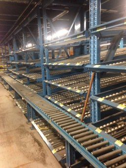 A conveyor belt in a warehouse with empty shelves