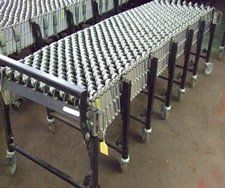 A conveyor belt with wheels is sitting on the floor.