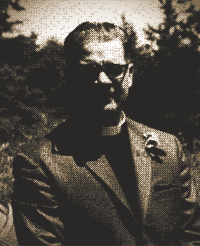 Person in glasses and a jacket standing outdoors in bright sunlight, with trees blurred in the background