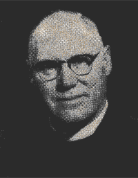 Black-and-white portrait of a man wearing glasses and a dark suit, facing forward with a neutral expression