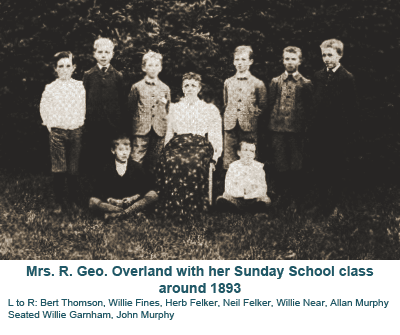Mrs. R. Geo. Overland with Sunday School class around 1893, posed outdoors in formal dress