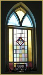 Stained-glass church window with arched top and colorful geometric panes