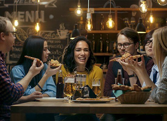 Young People Eat Slices of Pizza — Newtown, PA — Piccolo Trattoria Italian Catering Young People Eat Slices of Pizza — Newtown, PA — Piccolo Trattoria Italian Catering