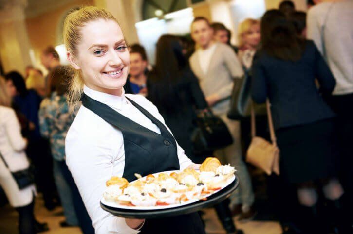 Woman Smiling While Serving Meals — Newtown, PA — Piccolo Trattoria Italian Catering