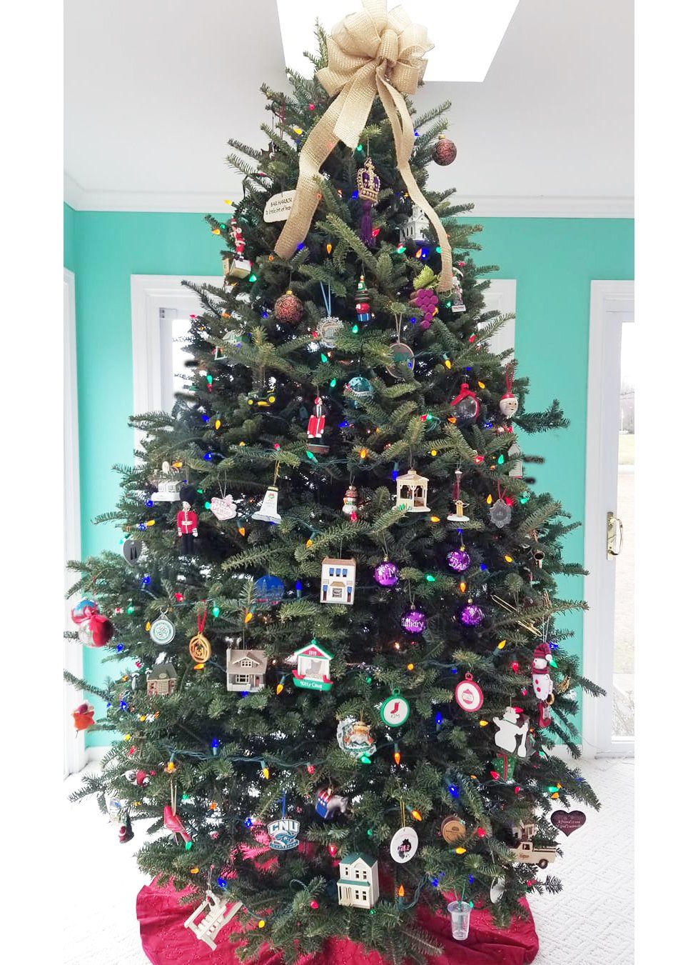 A large christmas tree is decorated with lots of ornaments and lights.