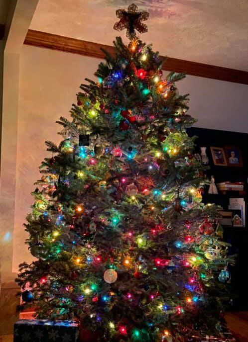 A christmas tree with a star on top is in a living room