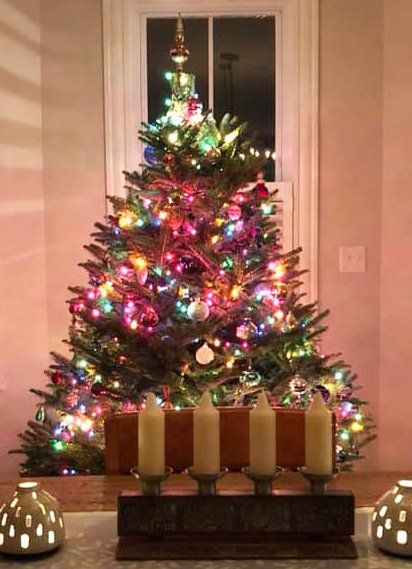 A christmas tree with candles in front of it
