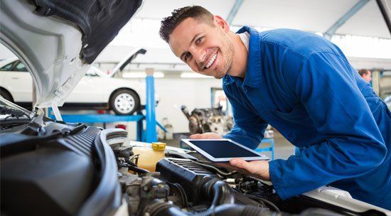 Mechanic Holding a Tablet — Elmira, NY — Steve's American Lifetime Muffler Mechanic Holding a Tablet — Elmira, NY — Steve's American Lifetime Muffler