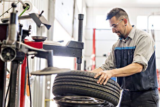 Mechanic Replacing the Car Tire — Elmira, NY — Steve's American Lifetime Muffler Mechanic Replacing the Car Tire — Elmira, NY — Steve's American Lifetime Muffler