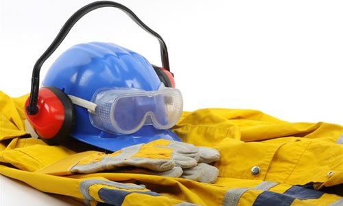 Casco azul, gafas de seguridad, orejeras, guantes y chaqueta de trabajo amarilla: equipo de protección.