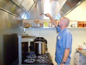 Worker checking vents — Fire Safety equipment in Corpus Christi, TX Worker checking vents — Fire Safety equipment in Corpus Christi, TX