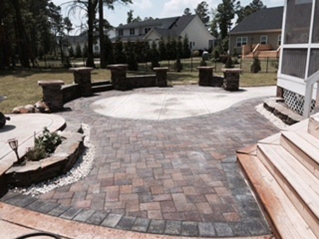 A patio with a screened in porch in the background