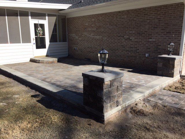 A brick house with a screened in porch and a patio