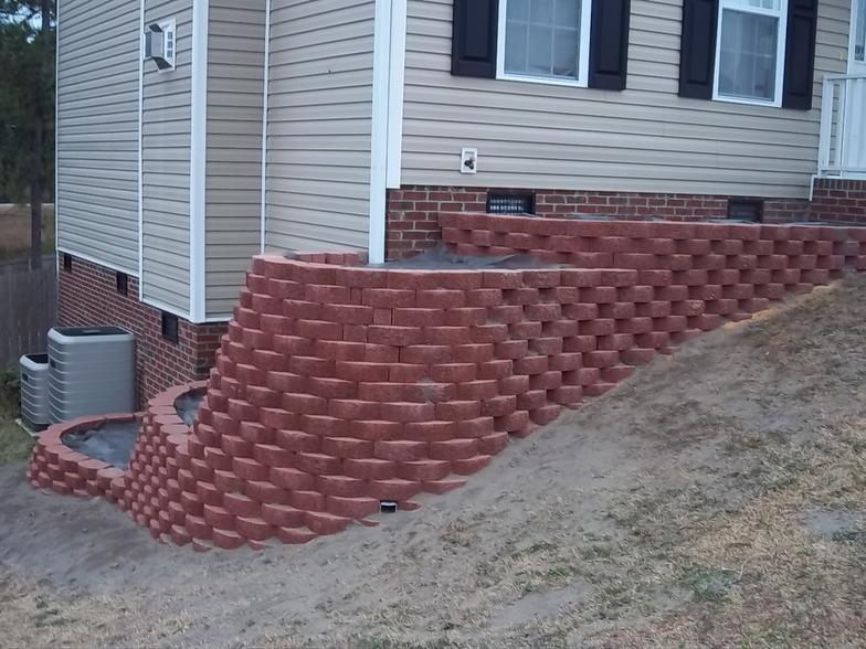 A house with a red retaining wall in front of it