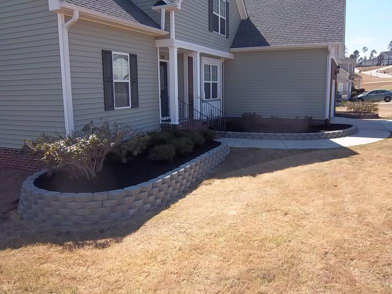 A house with a brick wall in front of it
