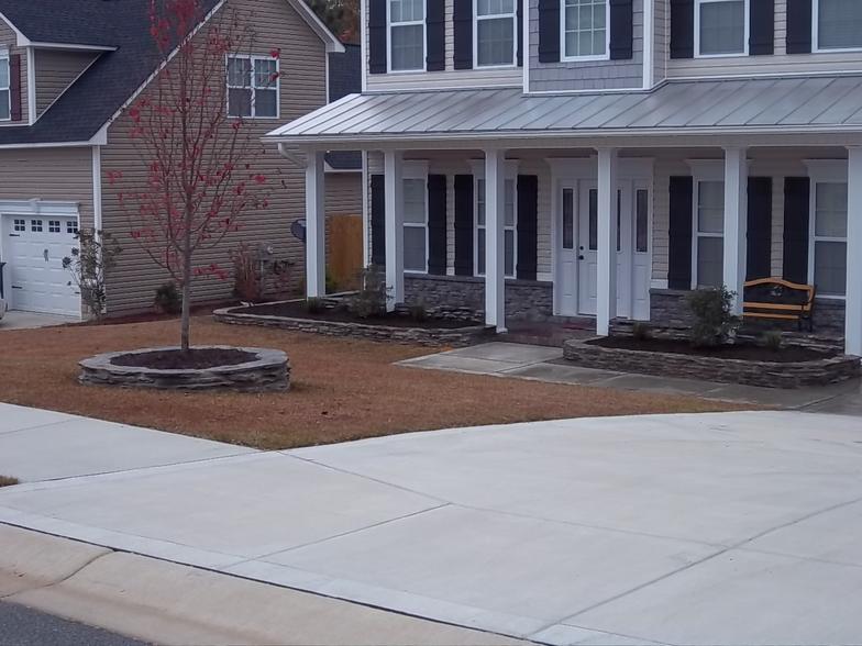 A house with a large porch and a concrete driveway