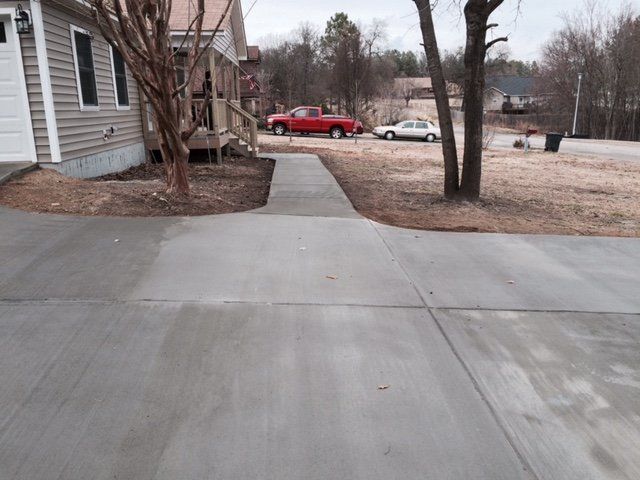 A red truck is parked in a driveway next to a house