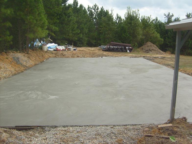 A large concrete slab in a field with trees in the background