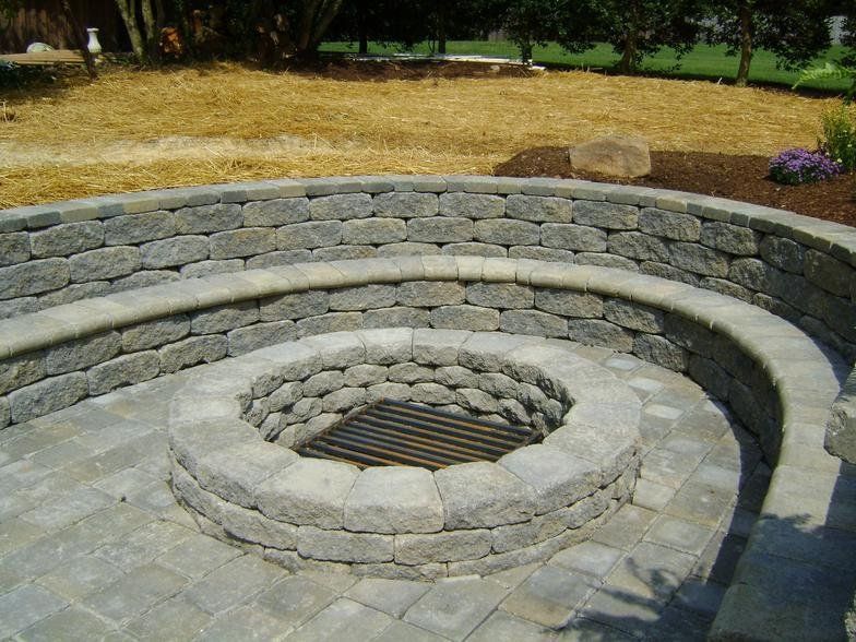 A fire pit is surrounded by a stone wall.
