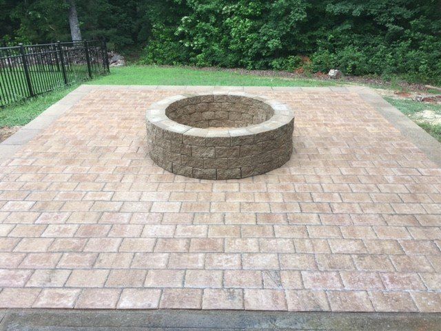 A fire pit is sitting on top of a brick patio.