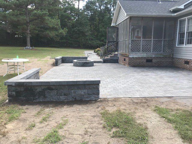A house with a screened in porch and a patio with a fire pit.