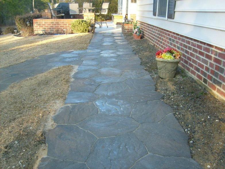 A stone walkway leading to a brick house