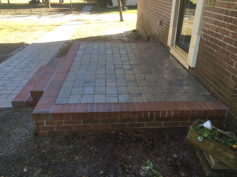 A brick patio is being built in front of a brick building.