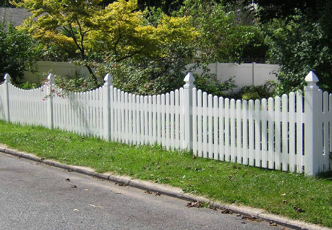 A white picket fence along the side of a road