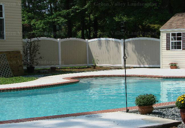 A large swimming pool with a white fence surrounding it