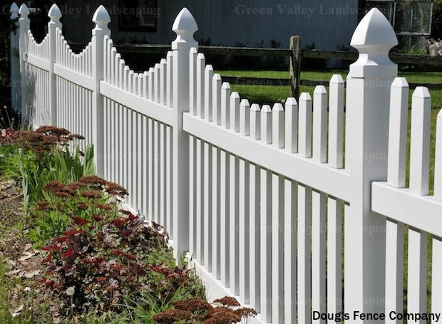 A white picket fence surrounds a lush green yard