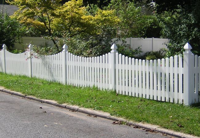 A white picket fence along the side of a road