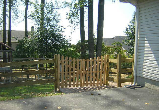 A wooden fence with a gate in front of a house