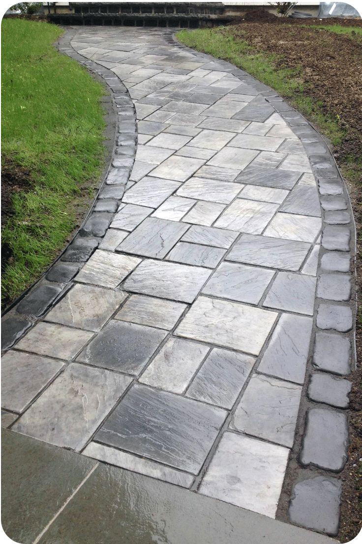 A brick walkway going through a grassy field.