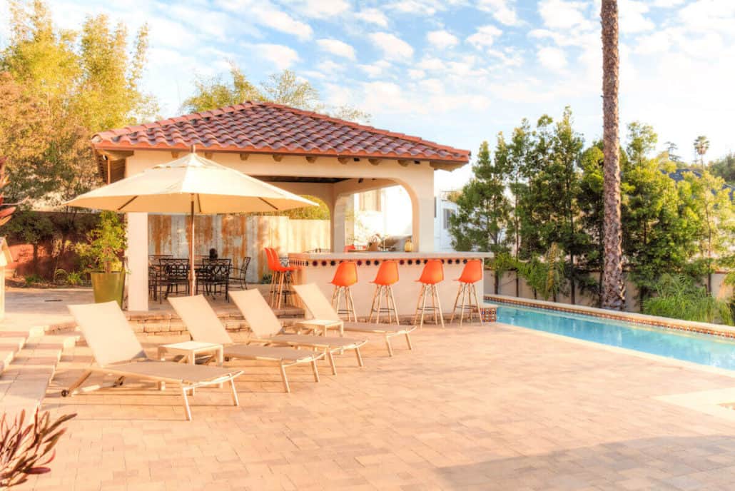 A swimming pool with chairs and umbrellas around it