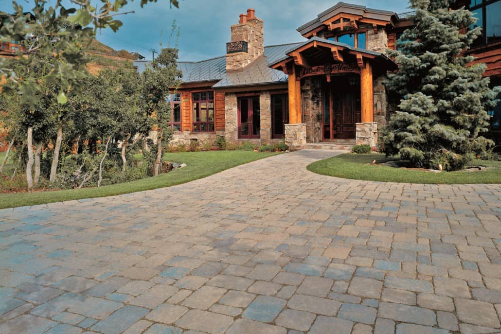 A large house with a brick driveway leading to it.