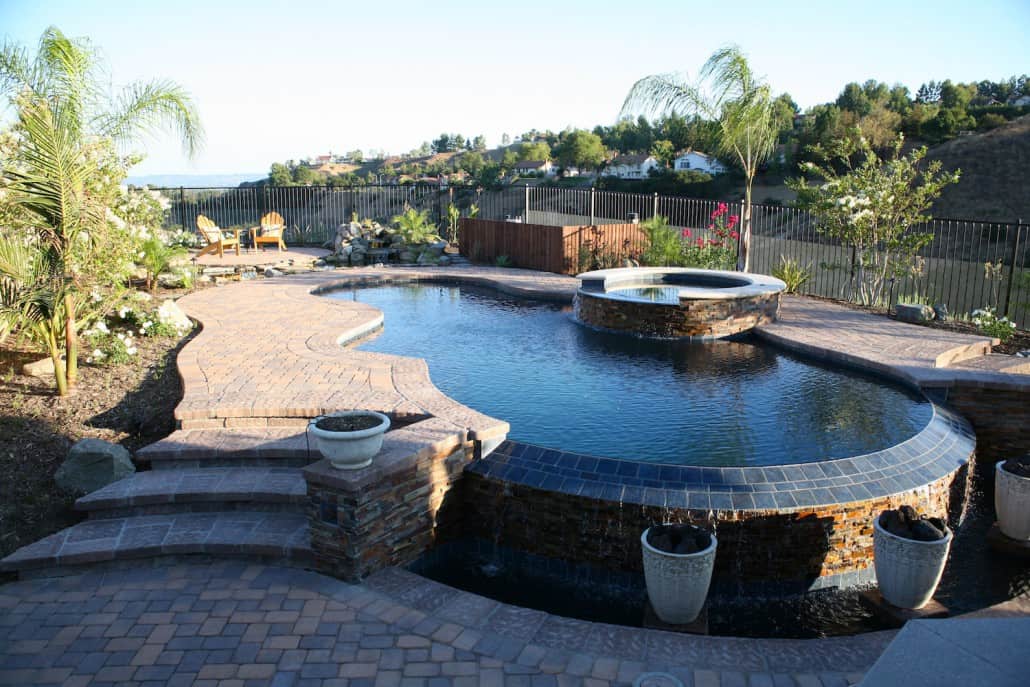 A large swimming pool with a hot tub in the middle